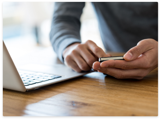 guy on laptop looking at phone